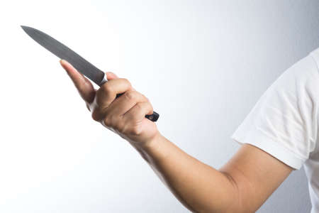 A hand holding knife on white backgroundの写真素材