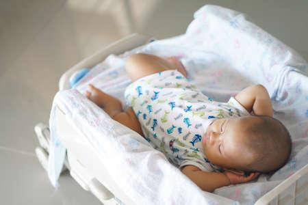 Asian baby sleeping in auto high chairの写真素材