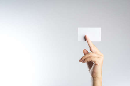 Hand hold blank card or paper on white backgroundの写真素材