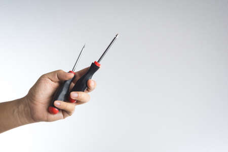 Hand holding screwdriver on white background