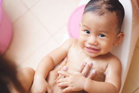 11 months Asian baby washing by his motherの写真素材
