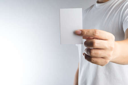 Hand hold blank card or paper on white backgroundの写真素材