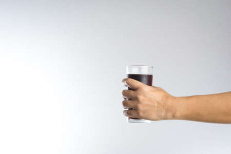 Hand holding a glass of soda water on white backgroundの写真素材