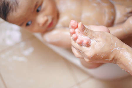 11 months Asian baby washing by his motherの写真素材