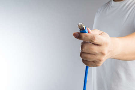 A LAN connector in hand on white backgroundの写真素材