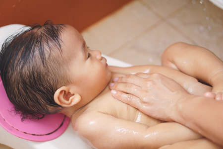 11 months Asian baby washing by his mother
