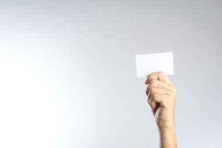 Hand hold blank card or paper on white backgroundの写真素材