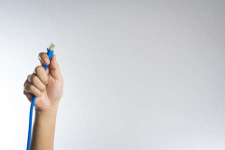 A LAN connector in hand on white backgroundの写真素材