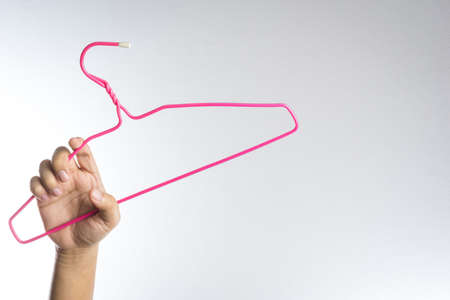 Hand is holding plastic hanger for hitting somethingの写真素材