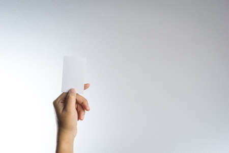 Hand hold blank card or paper on white backgroundの写真素材
