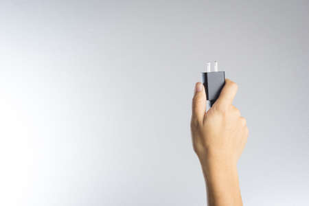 Electric phone adapter in a hand on white backgroundの写真素材