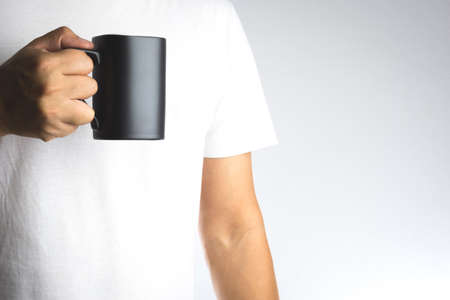 Hand hold dark cup of drink on white backgroundの写真素材