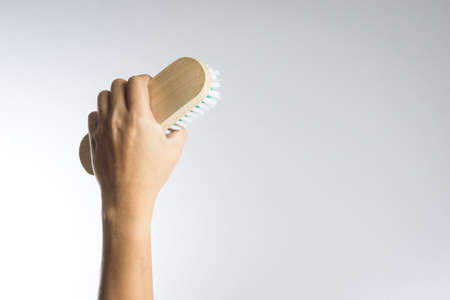 Hand holding brush on white backgroundの写真素材