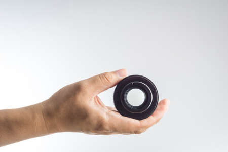 Hand holding vintage camera len on white backgroundの写真素材