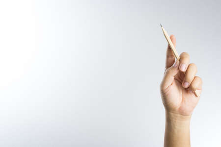 Left hand holding a pencil isolated on white backgroundの写真素材