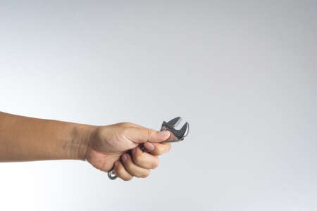 Hand holding wrench on white backgroundの写真素材