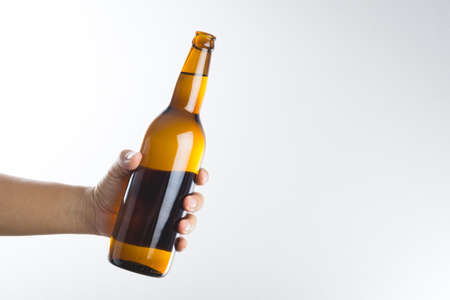 Hand holding a beer bottle without label isolated on white backgroundの写真素材