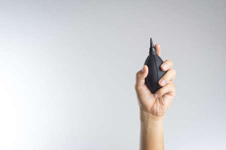 Hand holding camera air blower on white backgroundの写真素材
