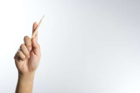 Right hand holding a pencil isolated on white backgroundの写真素材