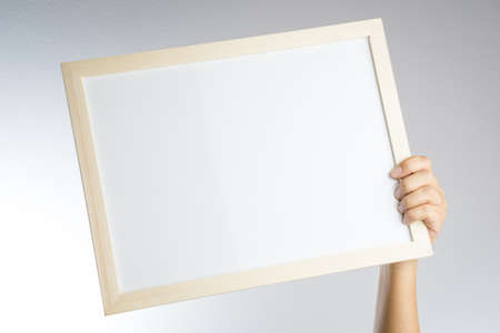 Hand holding blank wooden frame on white backgroundの写真素材