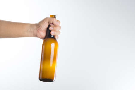 Hand holding a beer bottle without label isolated on white backgroundの写真素材