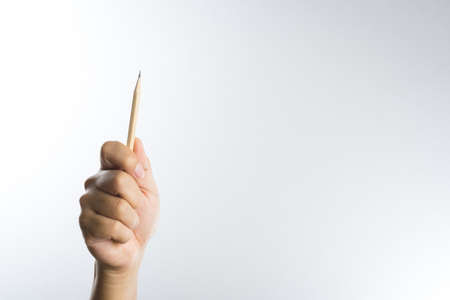 Right hand holding a pencil isolated on white backgroundの写真素材