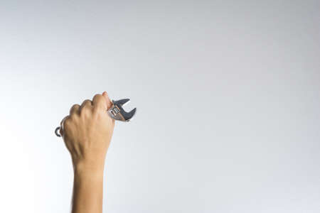 Hand holding wrench on white backgroundの写真素材