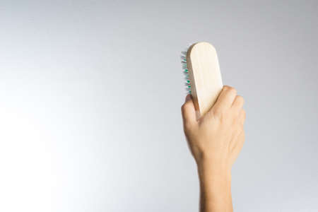 Hand holding brush on white background