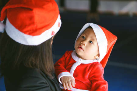 Asian mother holding 11 months old baby in santa suitの写真素材
