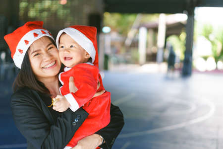 Asian mother holding 11 months old baby in santa suitの写真素材