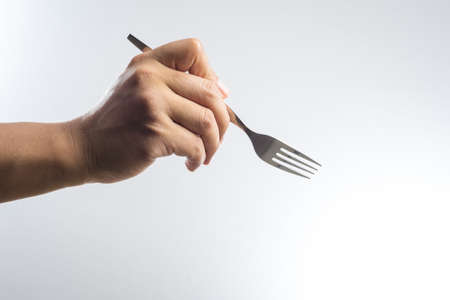 Man hand holding a silver fork on white background