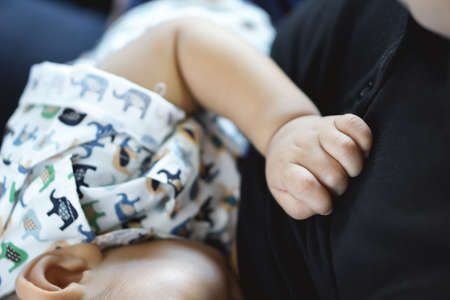 A year old Asian baby Breastfeeding by his mother