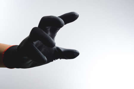 A hand wearing black glove with action gestureの写真素材