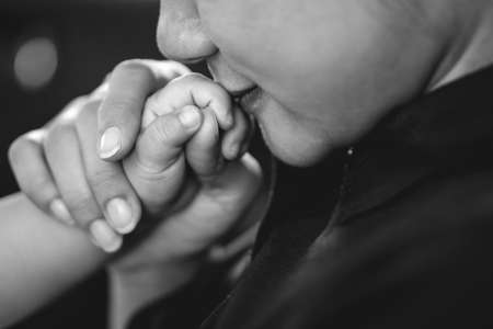 A year old Asian baby holding hand with his mother while breastfeedingの写真素材