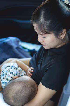 A year old Asian baby Breastfeeding by his motherの写真素材