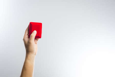 A man Hand holding a Red velvet box on white backgroundの写真素材