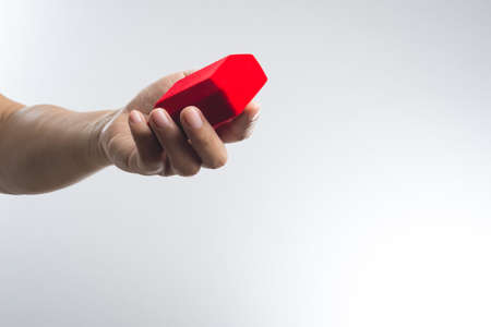 A man Hand holding a Red velvet box on white background