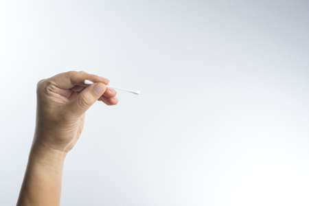 Hand with cotton swab on white backgroundの写真素材