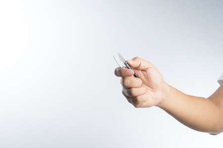 Hand holding thread scissors for making cloth and bag on white backgroundの写真素材