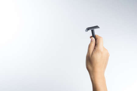 Hand with vintage shaving razor on white backgroundの写真素材