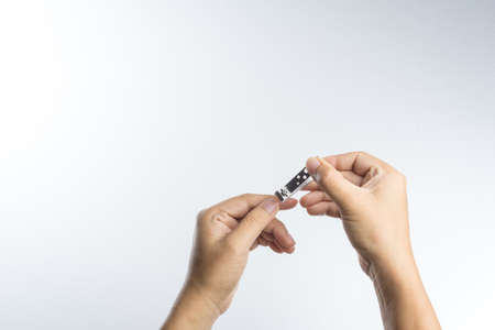 Hand with nail clipper on white background