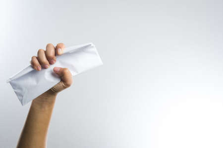 hand holding envelope hard on white backgroundの写真素材