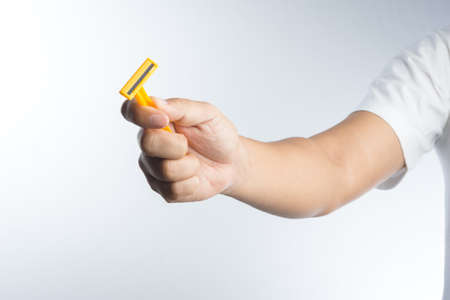 Hand with shaving razor on white backgroundの写真素材