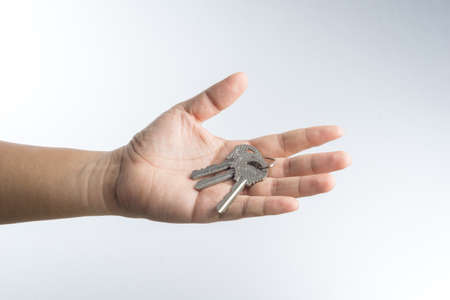 Hand giving keys on white backgroundの写真素材