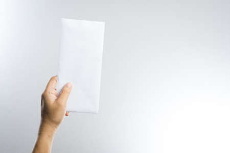 hand holding envelope on white backgroundの写真素材