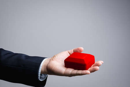Business man hand holding red gift box on white backgroundの写真素材