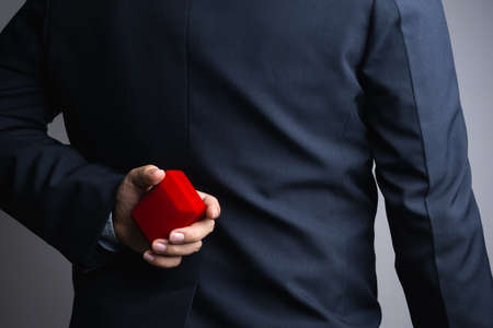 Business man hand holding red gift box on white backgroundの写真素材