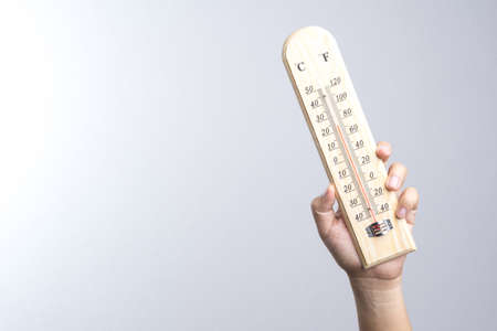 Hand holding classic thermometer on white background