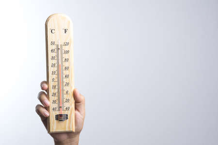 Hand holding classic thermometer on white backgroundの写真素材