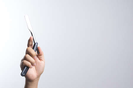 Hand holding razor use in barber on white backgroundの写真素材